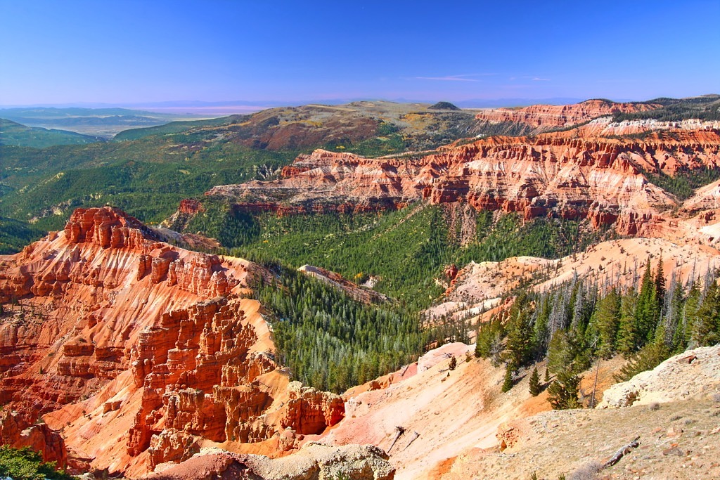 The Cedar Breaks amphitheater, red and white rock spires dropping away into forest.