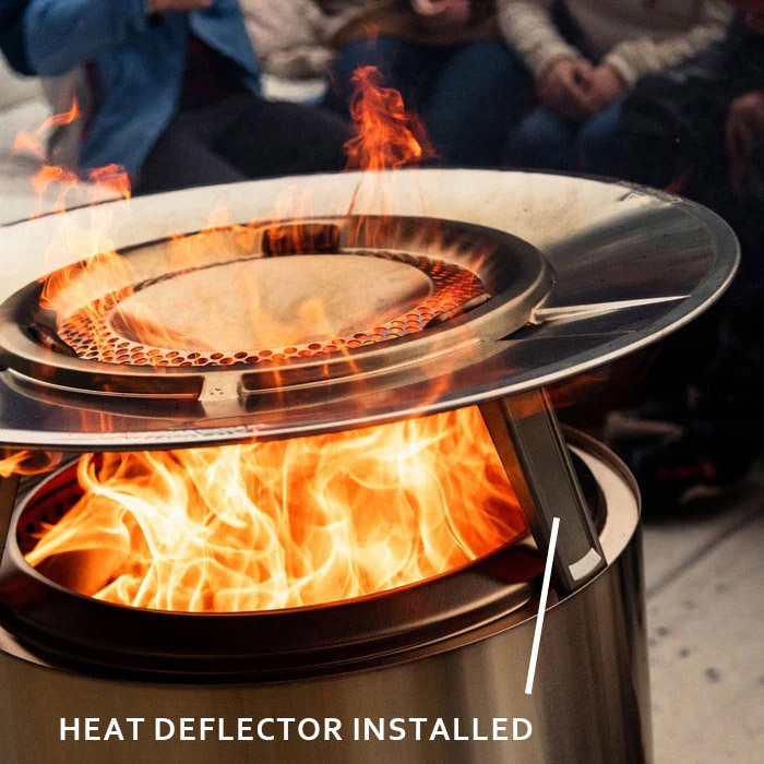 The heat deflector seated on its stand above the flames, throwing heat outward.