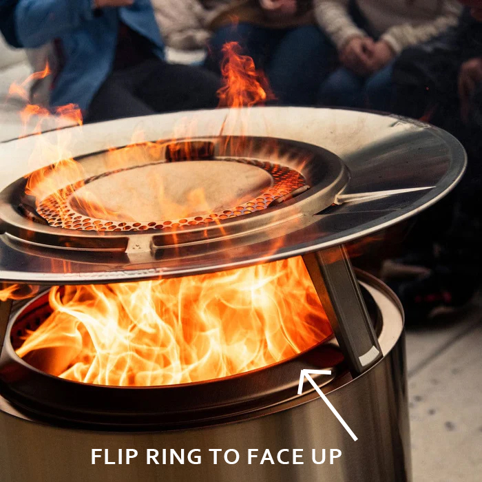 The fire pit burning with an arrow marking the inner ring flipped to face up.