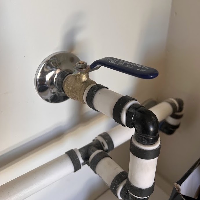 The interior ball valve in the laundry room with the handle in line with the pipe, open.